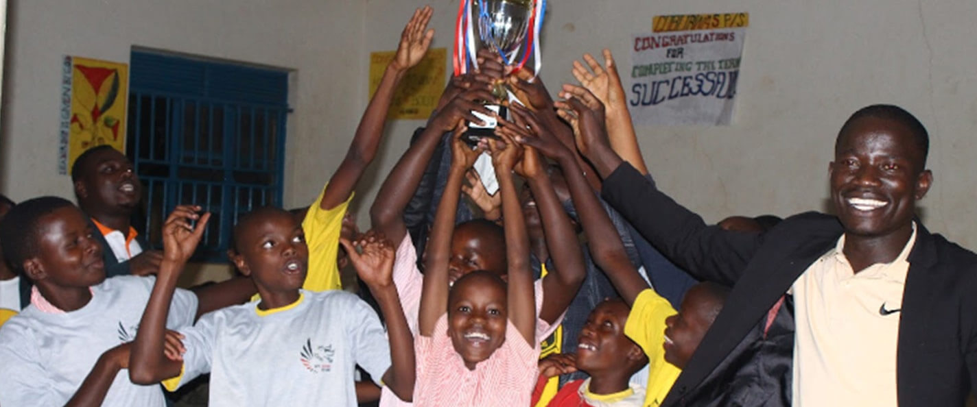 Ugandan students hold up a trophy after winning a 5 STA-Z tournament.