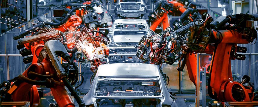 Robotic automation building cars in a manufacturing plant.