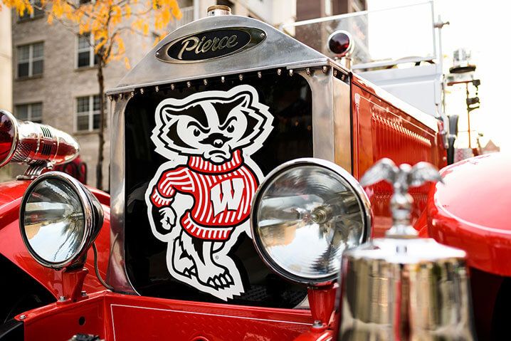 A detail photo of the headlights and Buckly Badger graphic on the front of the red Bucky Wagon