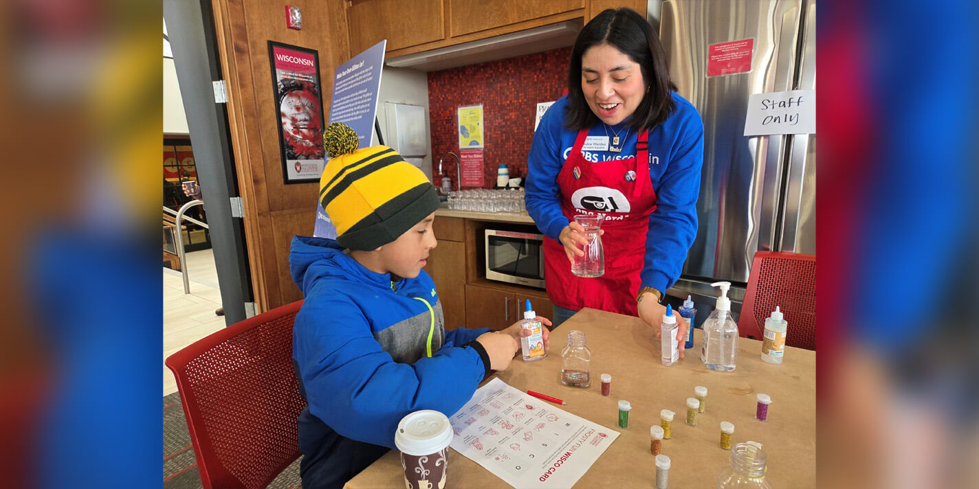 Adult helping a child paint on a piece of paper