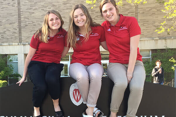 Students sitting on a sign