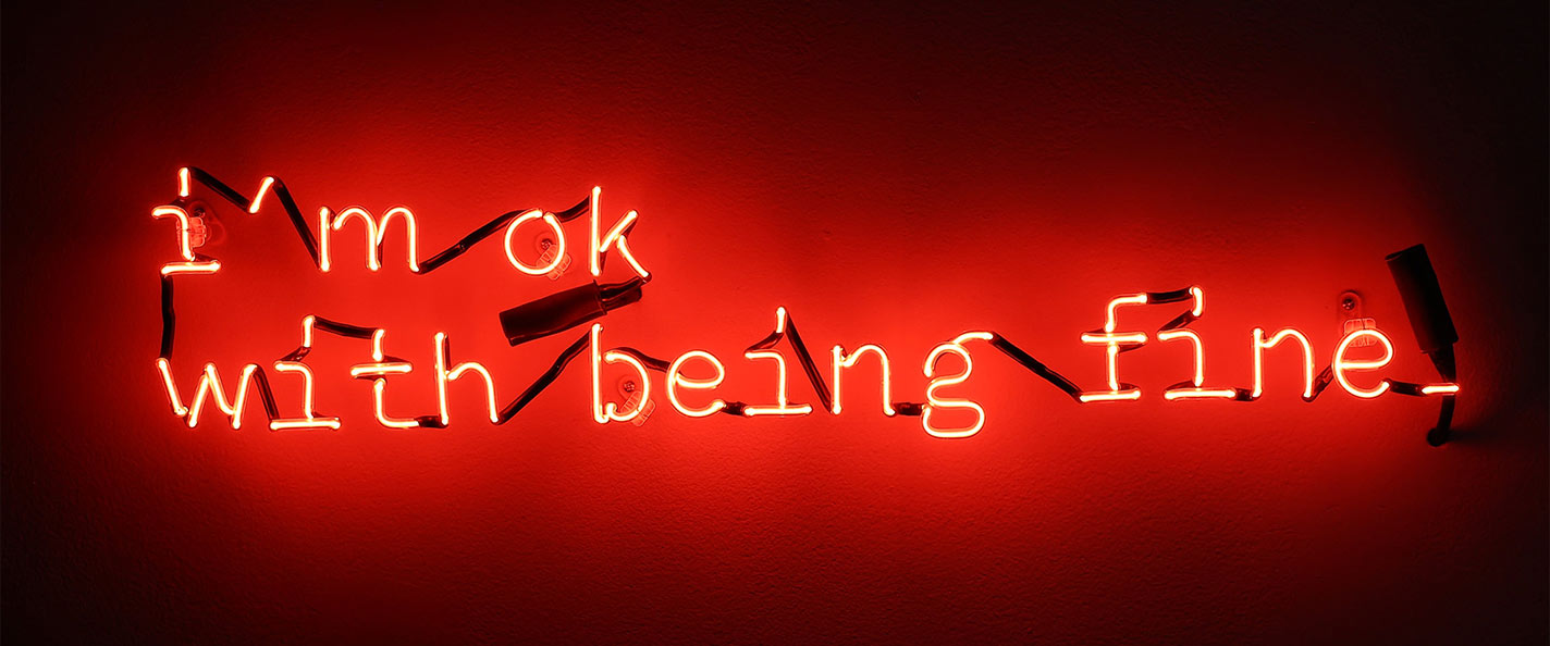 Neon red text in a short, serif typewriter font reads, "I'm ok with being fine" set against a black background.