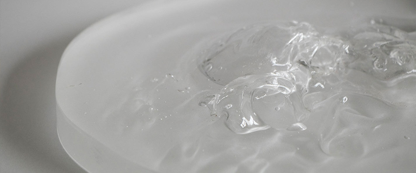 A close-up of a glass disc with a mottled surface on a white backdrop.