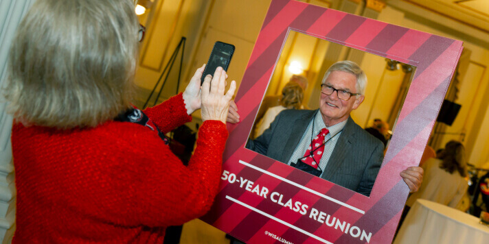 A person posing with a frame for a photo