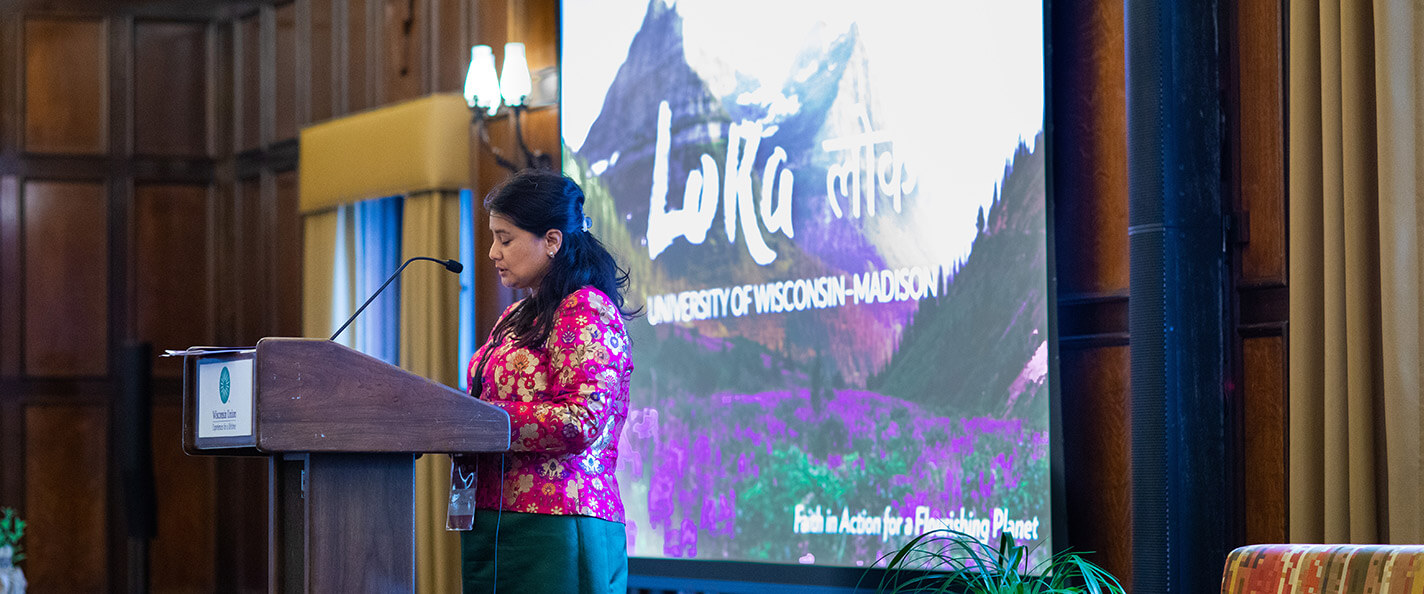 Chungyalpa speaks at a podium.