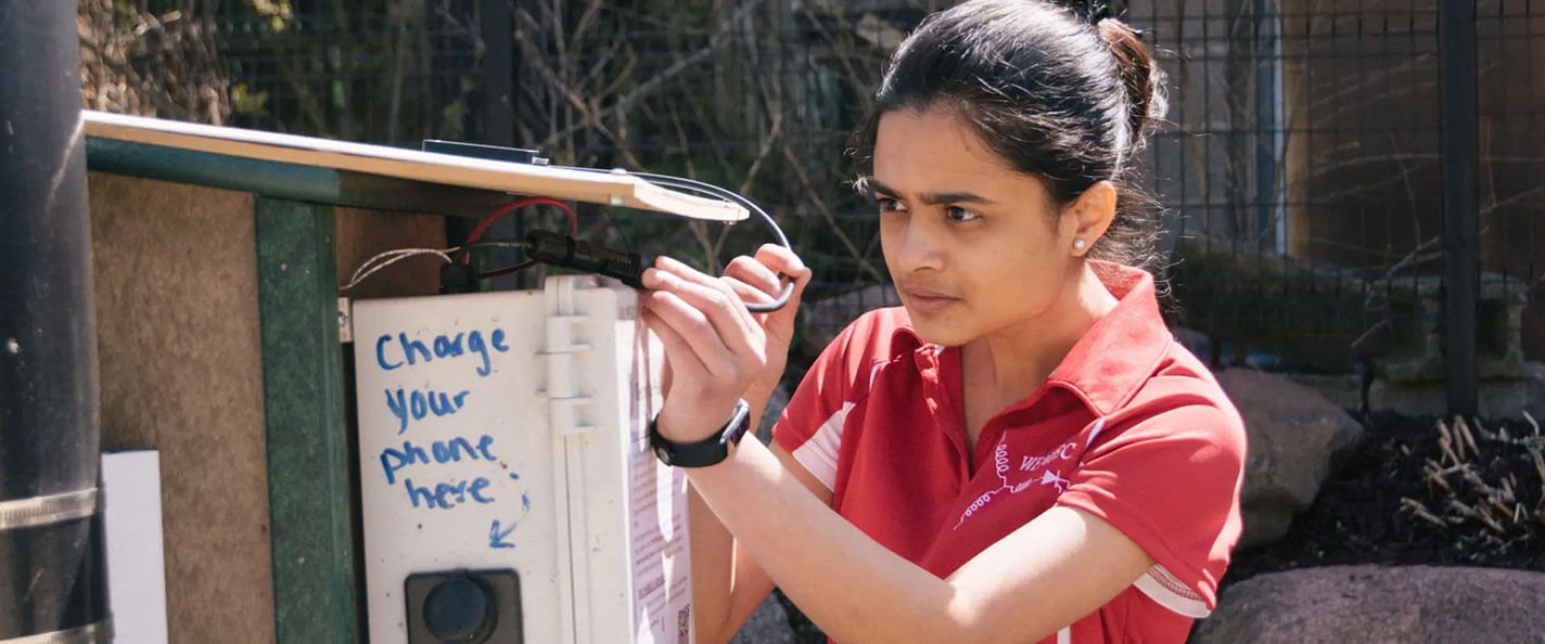 A student installs an e-Little Free Library.